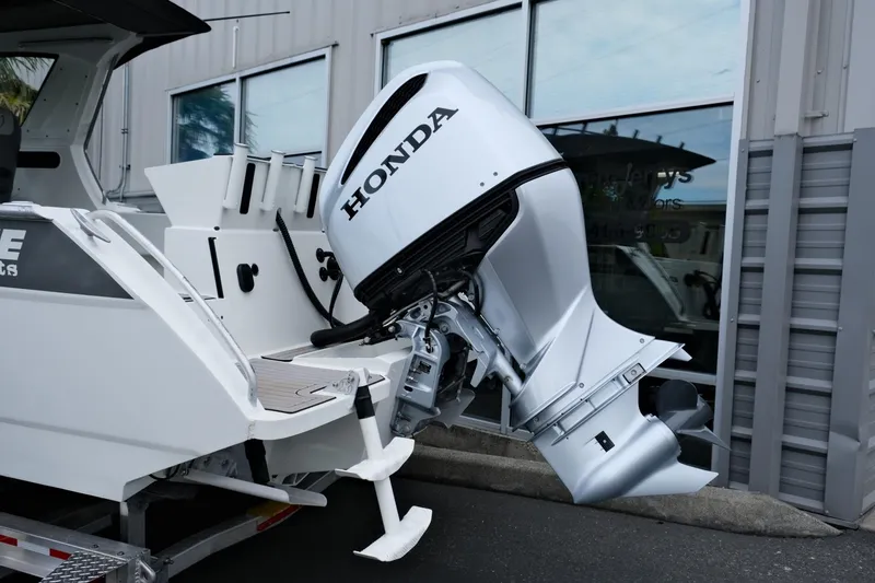 Slide: The Image of 2023 Extreme Boats 745 Game King with Honda outboard motor, docked near a building. - 6
