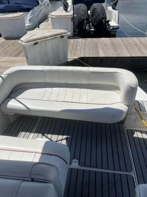 Slide: The Image of 1996 Sea Ray Sundancer boat with white seating and docked at a marina. - 6