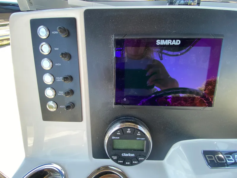 Slide: The Image of 2026 Robalo R200 Center Console dashboard with Simrad display and Clarion audio controls. - 10