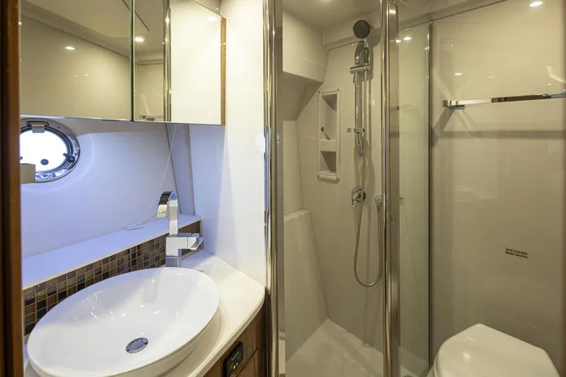 Slide: The Image of Modern bathroom in 2018 Cruisers Yachts 45 Cantius with shower, sink, and porthole. - 17