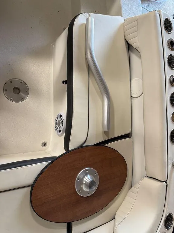 Slide: The Image of 2024 Stingray 192SC boat interior with beige seating, wooden table, and metal handle. - 13