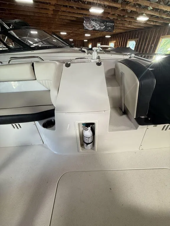 Slide: The Image of 2024 Stingray 192SC boat interior with seating and fire extinguisher, in a wooden boathouse. - 22