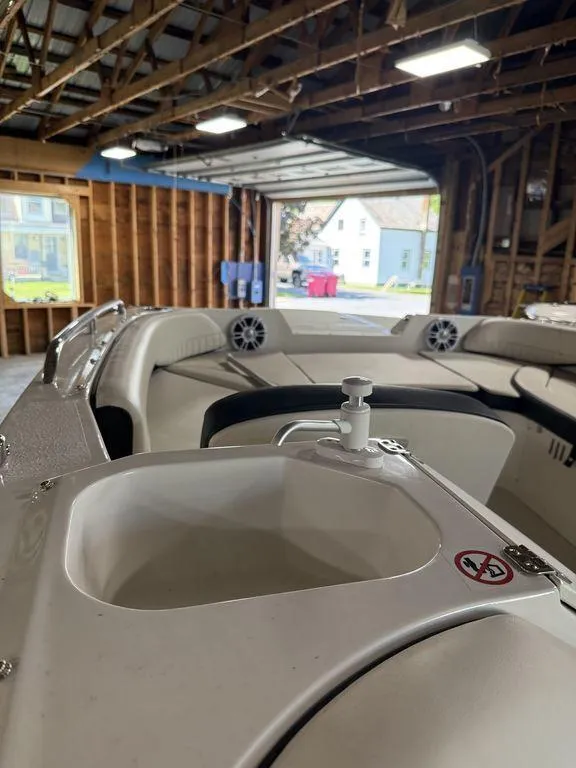 Slide: The Image of 2024 Stingray 192SC boat interior with seating and speakers in a garage. - 26