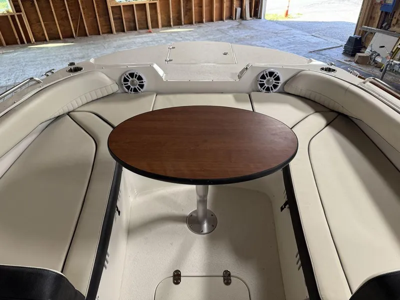 Slide: The Image of 2024 Stingray 192SC boat interior with round table and cushioned seating. - 27