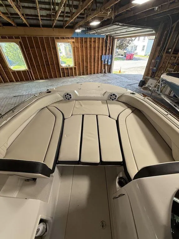 Slide: The Image of 2024 Stingray 192SC boat interior with beige seating in a wooden boathouse. - 29