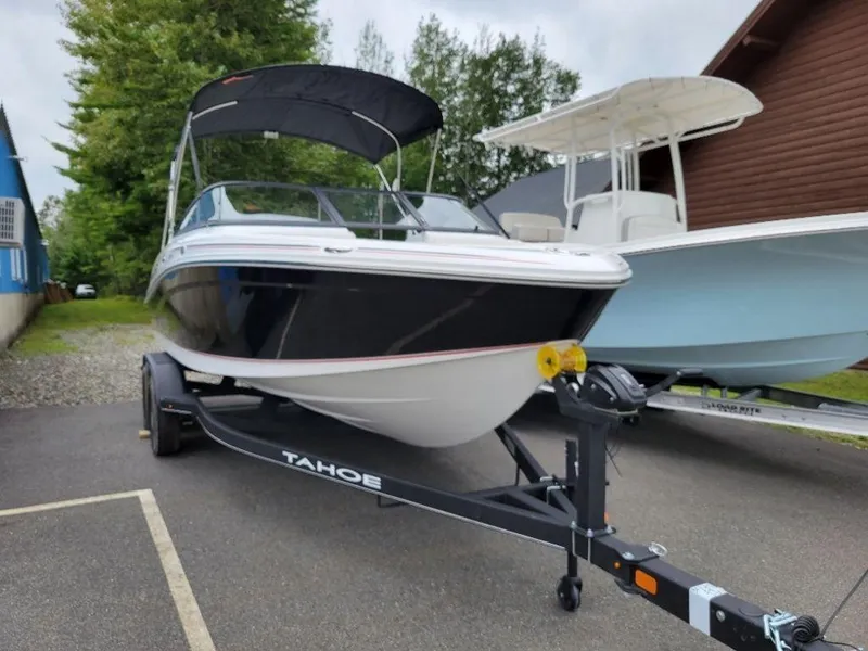 Slide: The Image of 2024 Tahoe 210 S boat on trailer with canopy in parking lot. - 14
