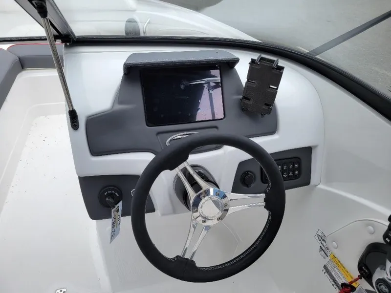 Slide: The Image of 2024 Tahoe 210 S boat dashboard with steering wheel and control panel. - 7
