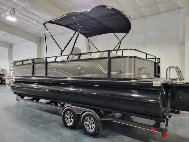 Slide: The Image of 2024 Regency 250 DL3 pontoon boat with black and gray exterior in indoor showroom. - 10