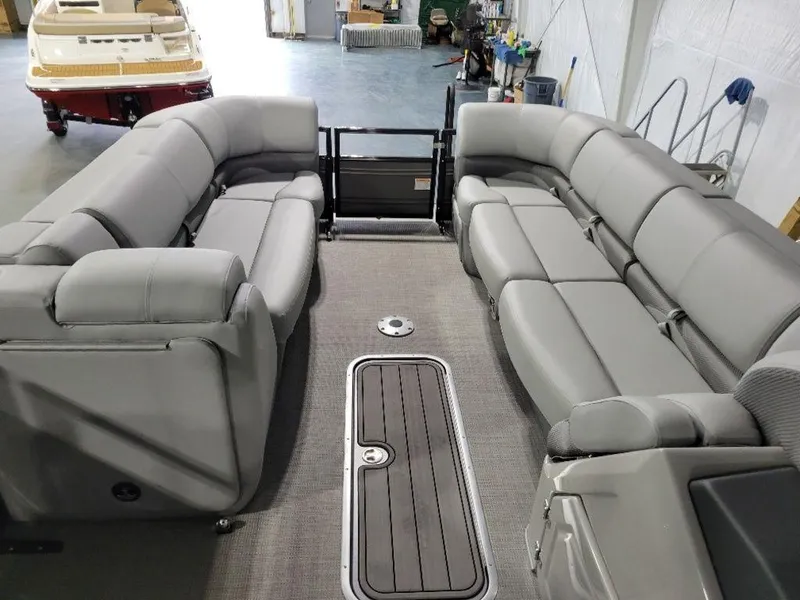 Slide: The Image of 2024 Regency 250 DL3 pontoon boat interior with gray seating and spacious layout. - 2