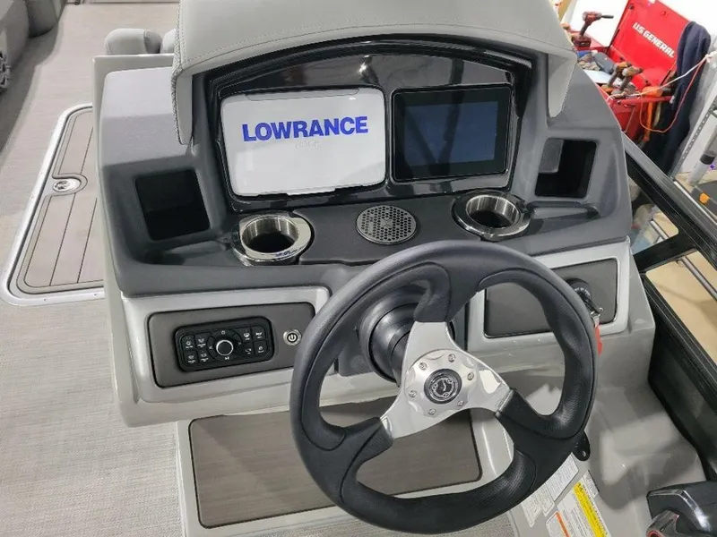 Slide: The Image of 2024 Regency 250 DL3 boat dashboard with Lowrance navigation system and steering wheel. - 3