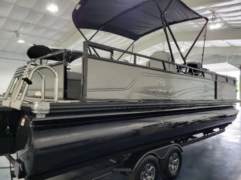 Slide: The Image of 2024 Regency 250 DL3 pontoon boat with black and gray design in indoor showroom. - 9