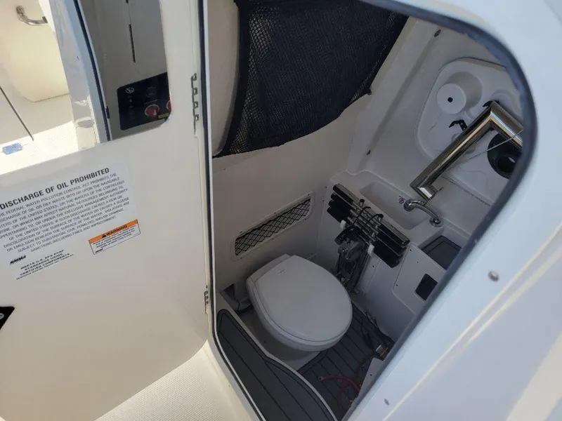 Slide: The Image of 2024 Sailfish 272 CC boat interior with compact marine toilet and sink. - 10
