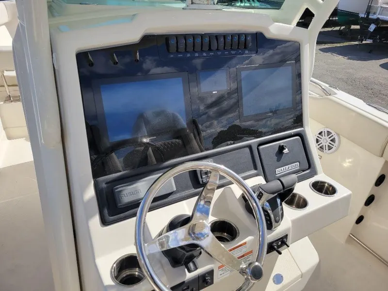 Slide: The Image of 2024 Sailfish 272 CC boat dashboard with dual screens and steering wheel. - 18
