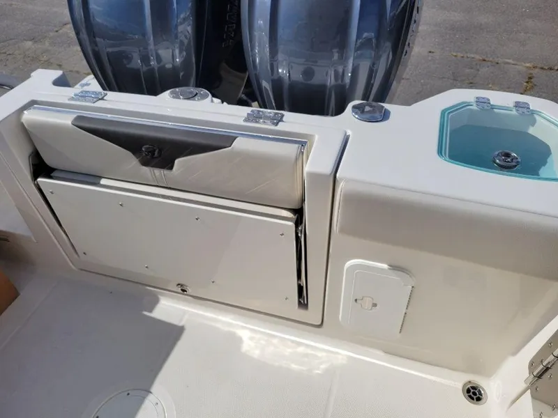 Slide: The Image of 2024 Sailfish 272 CC boat stern with dual outboard motors and storage compartments. - 5