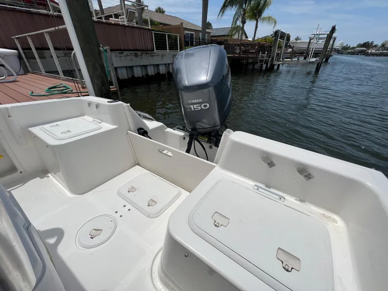Slide: The Image of 2004 Century 2000 Center Console boat with Yamaha 150 engine docked by waterfront. - 6