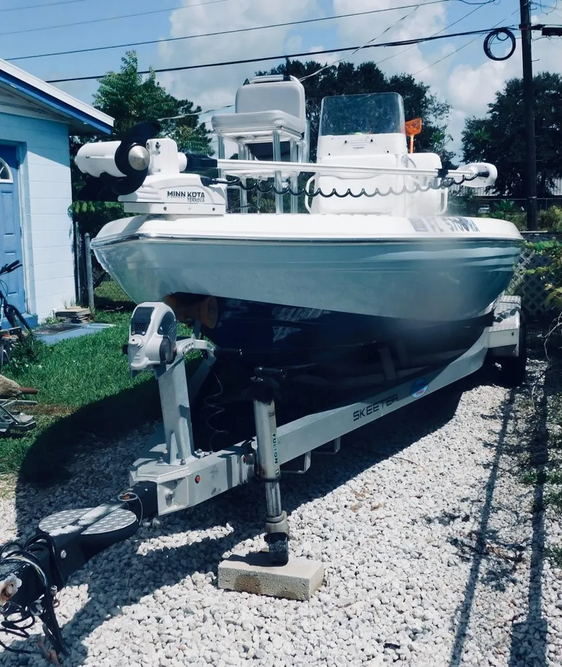Slide: The Image of 2016 Skeeter 240SX boat on trailer, parked on gravel driveway. - 1