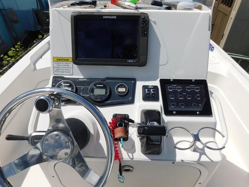 Slide: The Image of 2016 Skeeter 240SX boat dashboard with steering wheel and navigation system. - 13