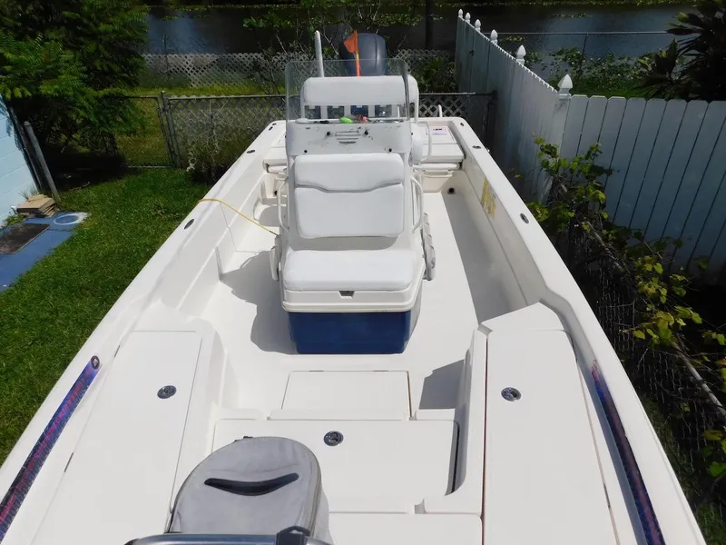 Slide: The Image of 2016 Skeeter 240SX boat with spacious deck and seating, docked near a garden. - 17