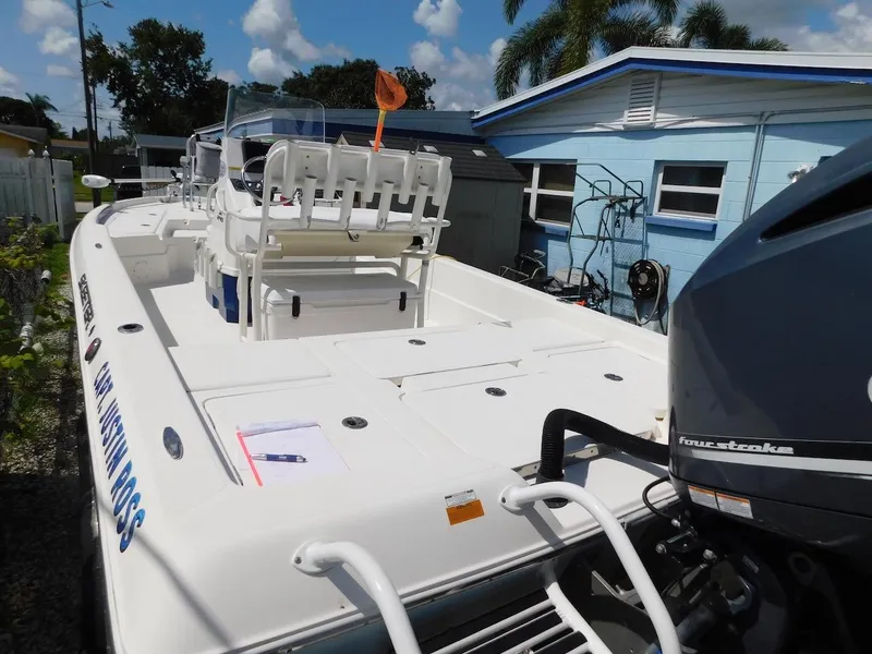 Slide: The Image of 2016 Skeeter 240SX boat with outboard motor, parked near a blue house. - 3
