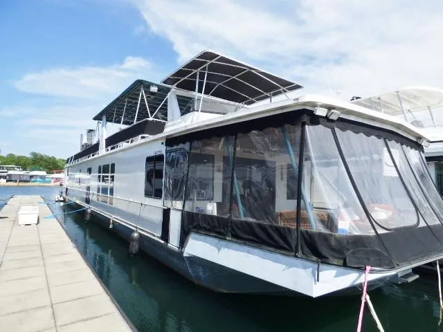 The Image of 1999 Stardust Cruisers 16x87 houseboat docked on a sunny day. - 0