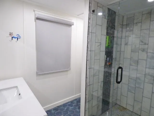 Slide: The Image of Modern bathroom with glass shower, hexagonal floor tiles, and white walls in a 1999 Stardust Cruisers. - 10