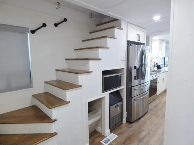 Slide: The Image of Modern kitchen interior with wooden stairs, stainless steel appliances, and white cabinetry in a 1999 Stardust Cruisers. - 4