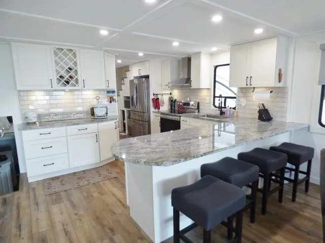 Slide: The Image of Modern kitchen in a 1999 Stardust Cruisers 16x87 houseboat with granite countertops and bar stools. - 5