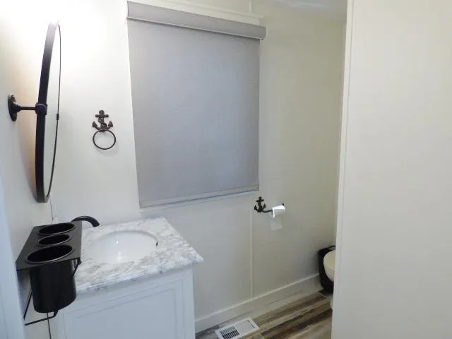 Slide: The Image of Bathroom in 1999 Stardust Cruisers 16x87 with marble countertop and nautical decor. - 8