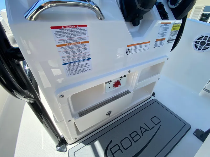 Slide: The Image of 2026 Robalo R200 Center Console dashboard with safety labels and storage compartments. - 12