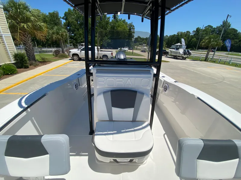 Slide: The Image of 2026 Robalo R200 Center Console boat interior with seating and console, parked outdoors. - 13