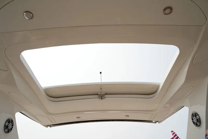 Slide: The Image of 2023 Sea Ray SLX 310 boat sunroof view with speakers and lighting. - 19