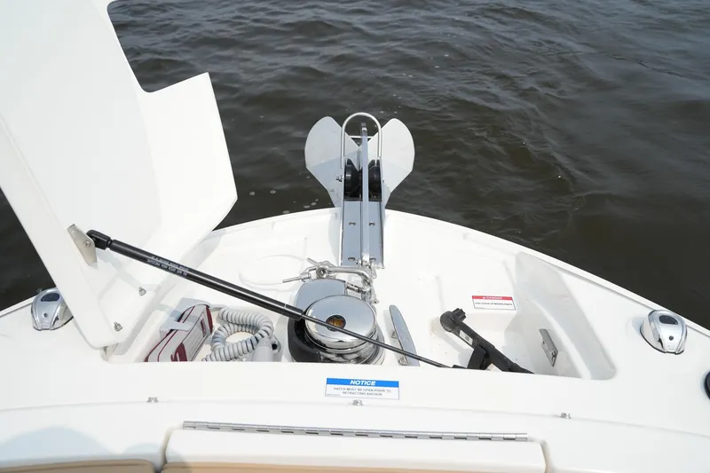 Slide: The Image of 2023 Sea Ray SLX 310 boat anchor compartment with open hatch on water. - 36