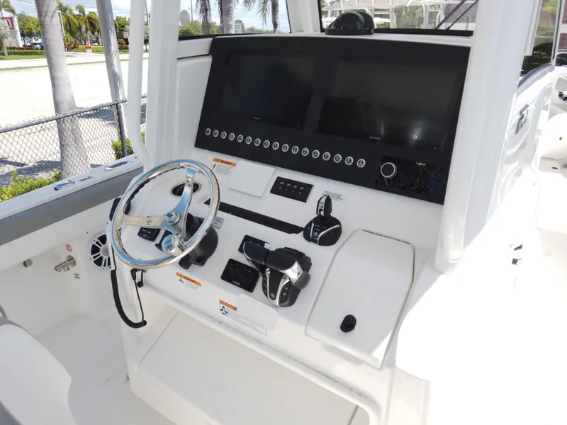 Slide: The Image of 2026 Regulator 28 boat dashboard with steering wheel and dual screens. - 16