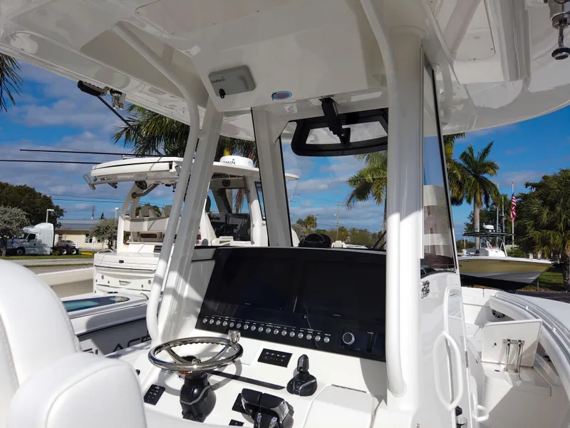Slide: The Image of 2026 Regulator 28 boat cockpit with modern controls and steering wheel, under clear blue sky. - 5