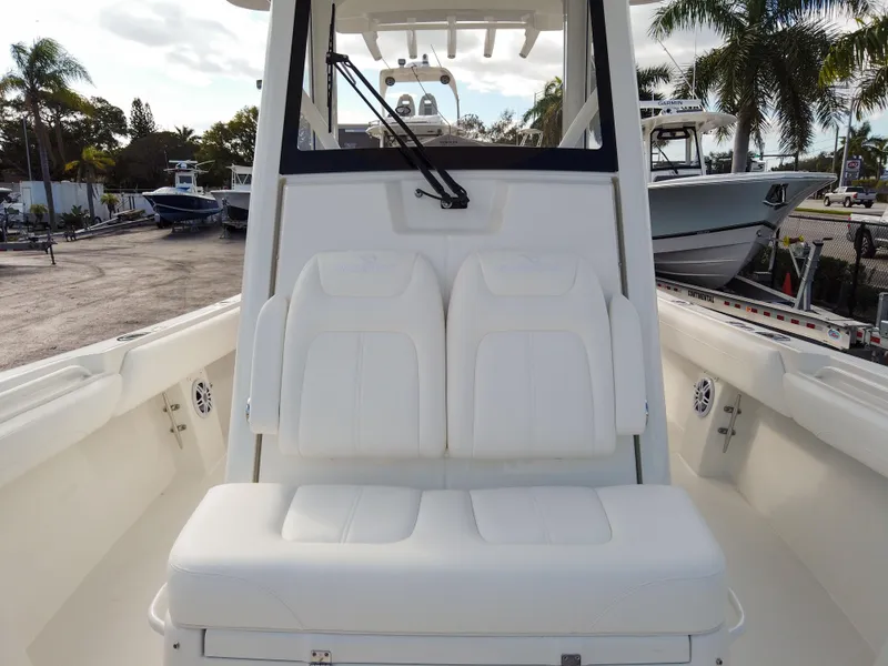Slide: The Image of 2026 Regulator 28 boat with white seating and console, docked outdoors. - 8