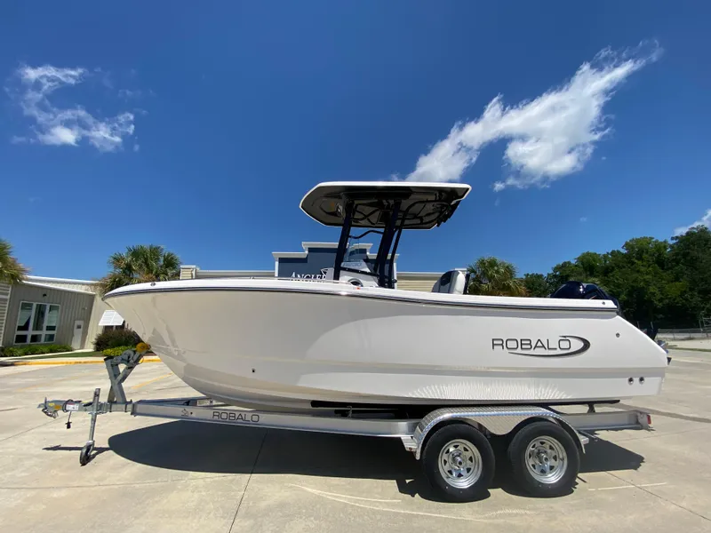 The Image of 2026 Robalo R230 Center Console boat on trailer under clear blue sky. - 0
