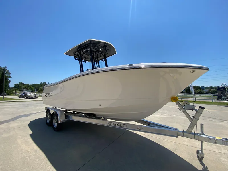 Slide: The Image of 2026 Robalo R230 Center Console boat on trailer under clear blue sky. - 1