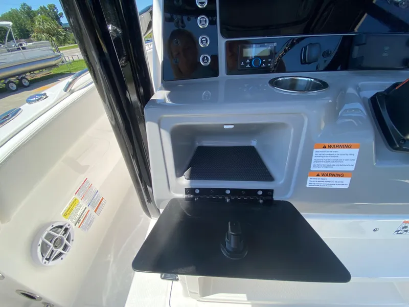 Slide: The Image of 2026 Robalo R230 Center Console boat dashboard with storage compartment and cup holder. - 16