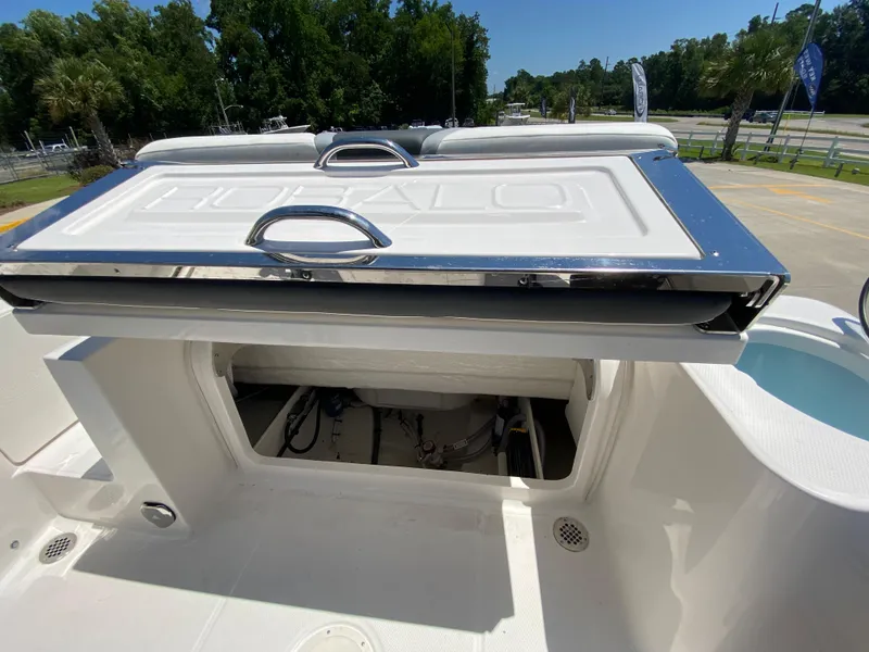 Slide: The Image of 2026 Robalo R230 Center Console boat with open storage compartment. - 9