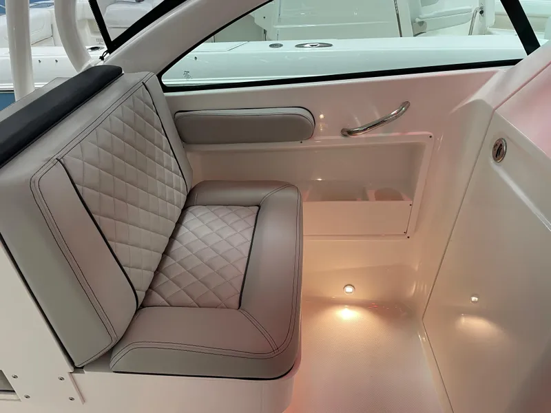 Slide: The Image of 2024 Pursuit DC 246 Dual Console interior seating with diamond-stitched upholstery and ambient lighting. - 10
