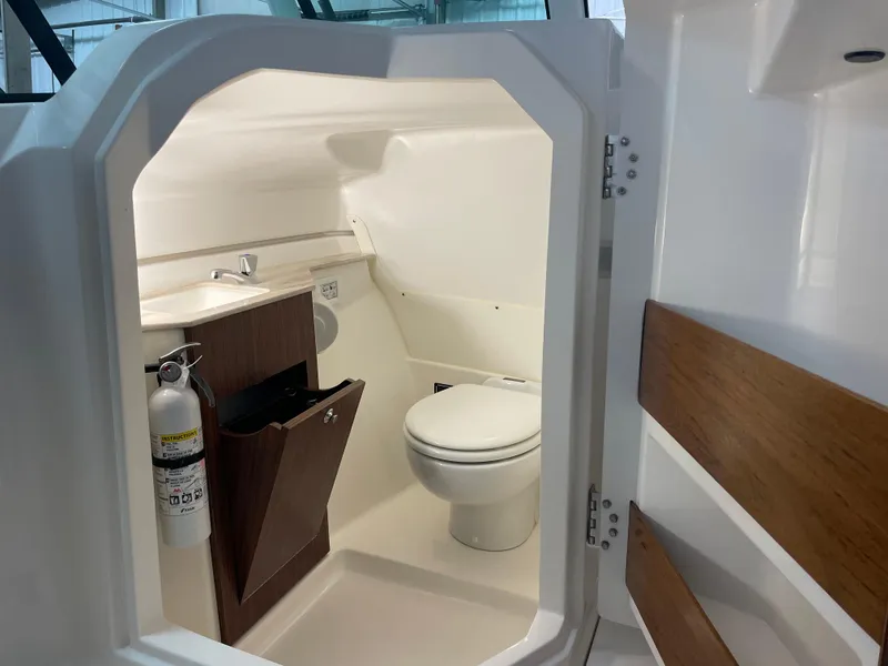 Slide: The Image of 2024 Pursuit DC 246 Dual Console boat interior with toilet and sink. - 13