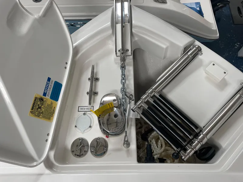 Slide: The Image of 2024 Pursuit DC 246 Dual Console anchor locker with chain, cleats, and ladder. - 19