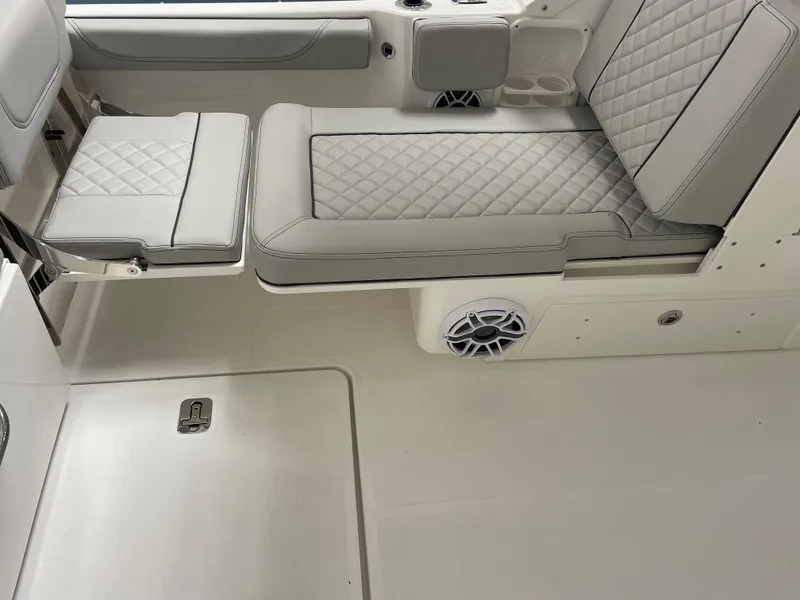 Slide: The Image of 2024 Pursuit DC 246 Dual Console boat interior with cushioned seating and speaker. - 24
