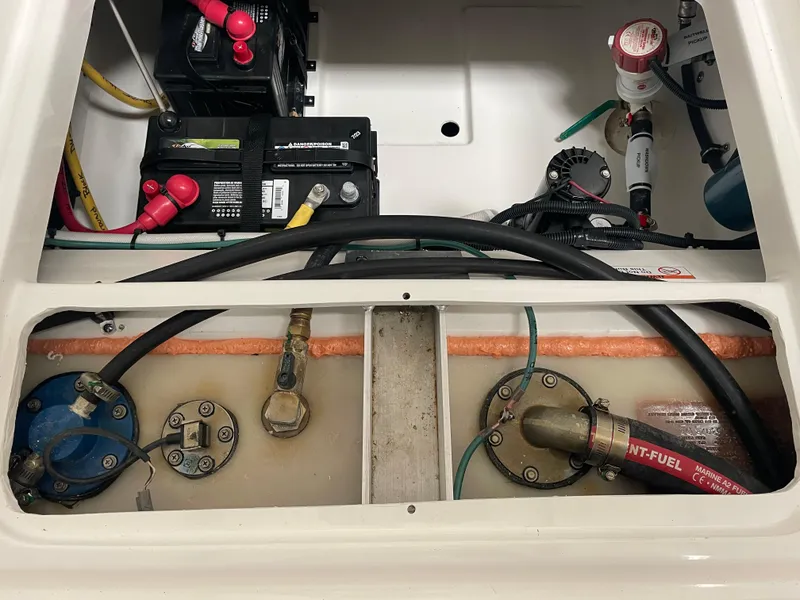 Slide: The Image of 2024 Pursuit DC 246 Dual Console boat engine compartment with batteries and fuel system. - 26