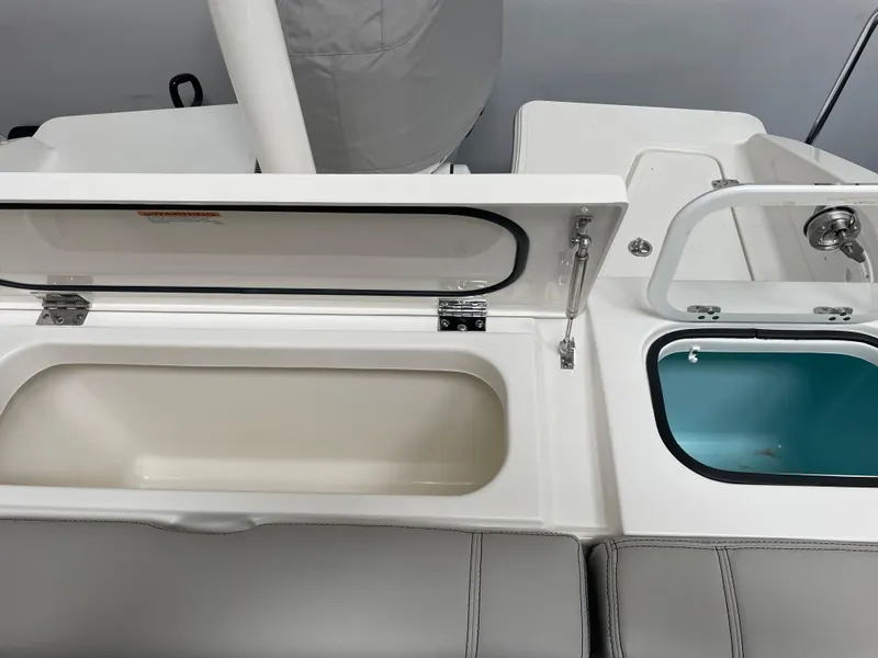 Slide: The Image of 2024 Pursuit DC 246 Dual Console boat storage compartments and sink. - 5