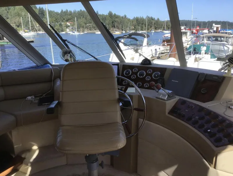 Slide: The Image of 2004 Meridian 490 Pilothouse interior with helm, overlooking marina and boats. - 9