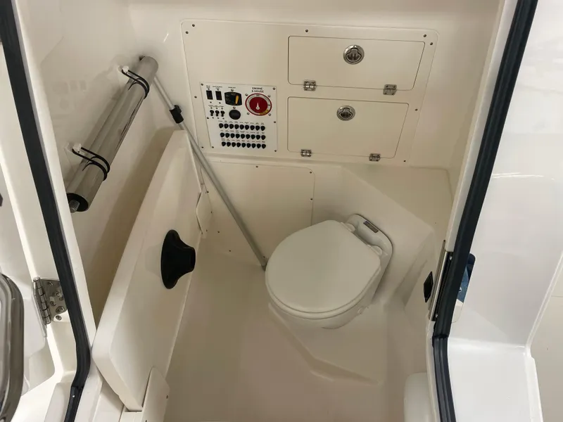 Slide: The Image of 2024 Pursuit S 248 Sport boat interior with toilet and control panel. - 11