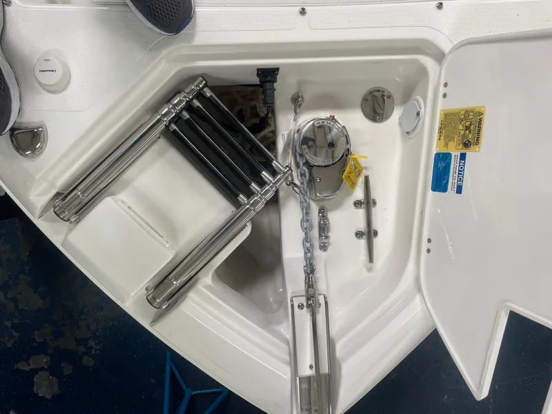 Slide: The Image of 2024 Pursuit S 248 Sport boat anchor compartment with stainless steel ladder and anchor chain. - 12