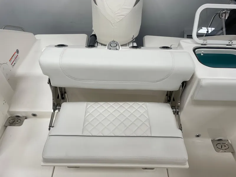Slide: The Image of 2024 Pursuit S 248 Sport boat with white cushioned seating and diamond-stitched pattern. - 13
