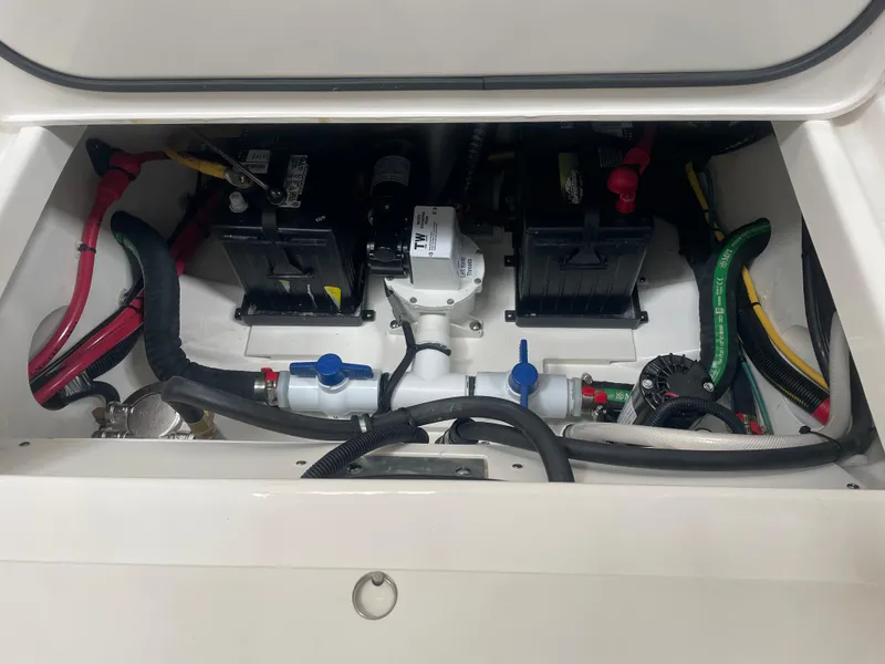 Slide: The Image of 2024 Pursuit S 248 Sport boat engine compartment with batteries and wiring. - 15